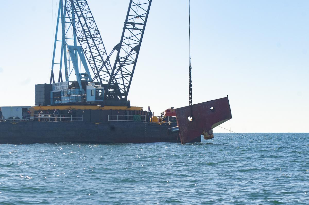 Rudder is lowered into water by crane