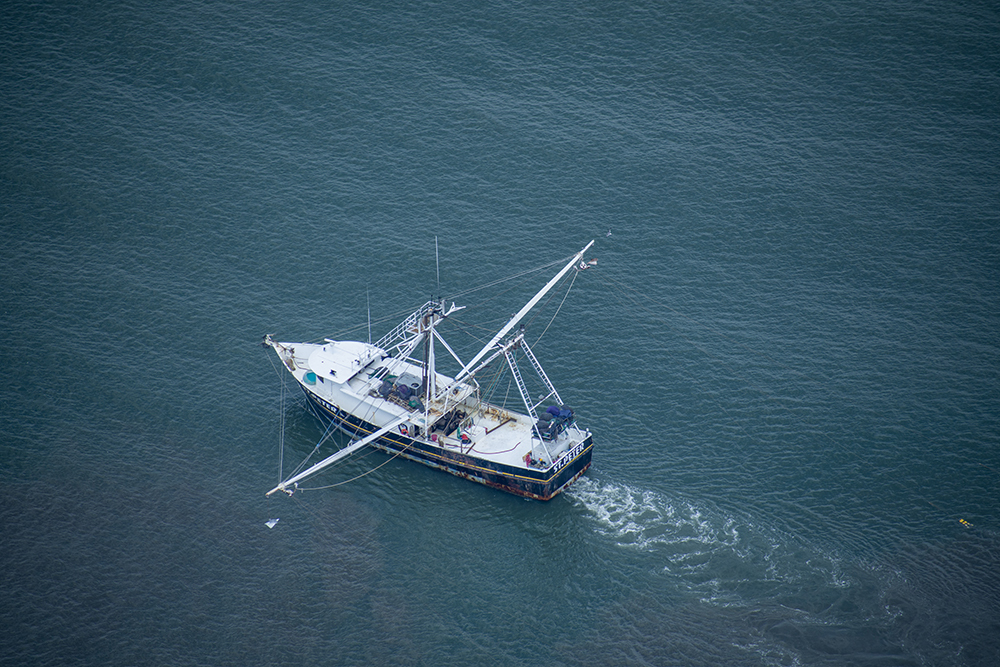 A shrimp boat off the coast on opening day of Shrimp Season from a helicopter