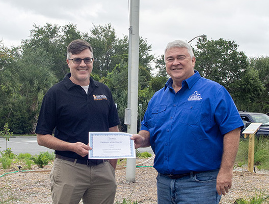Tyler Jones/CRD Eamonn Leonard, left, a botanist with WRD, poses in front of the Liberty Garden with CRD Director Doug Haymans.