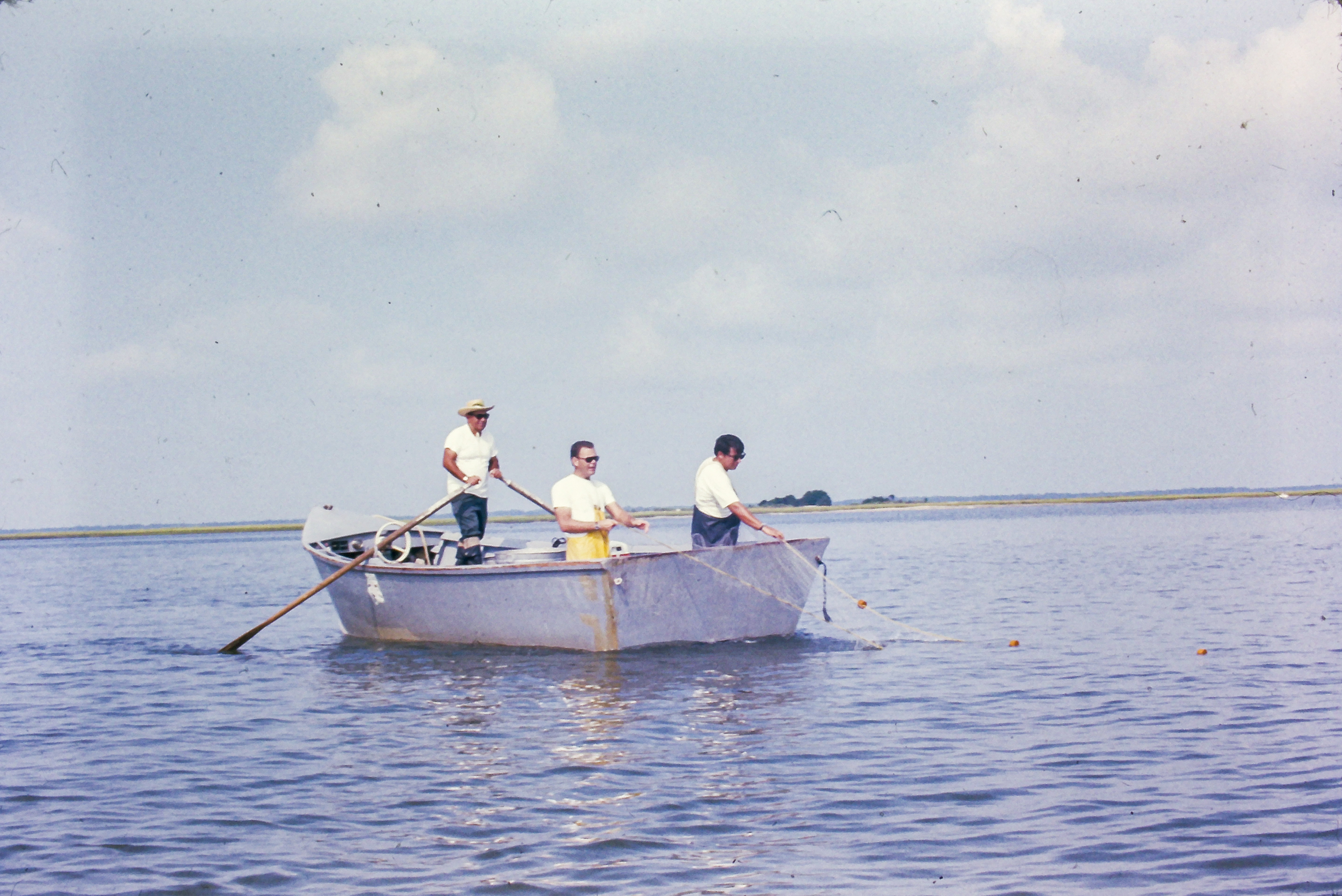 Jim Music, far right, helps pull in a gillnet with the late Capt. Pard Andrew (far left), and marine biologist Bobby Palmer as part of a total estuarine species inventory survey circa 1971.
