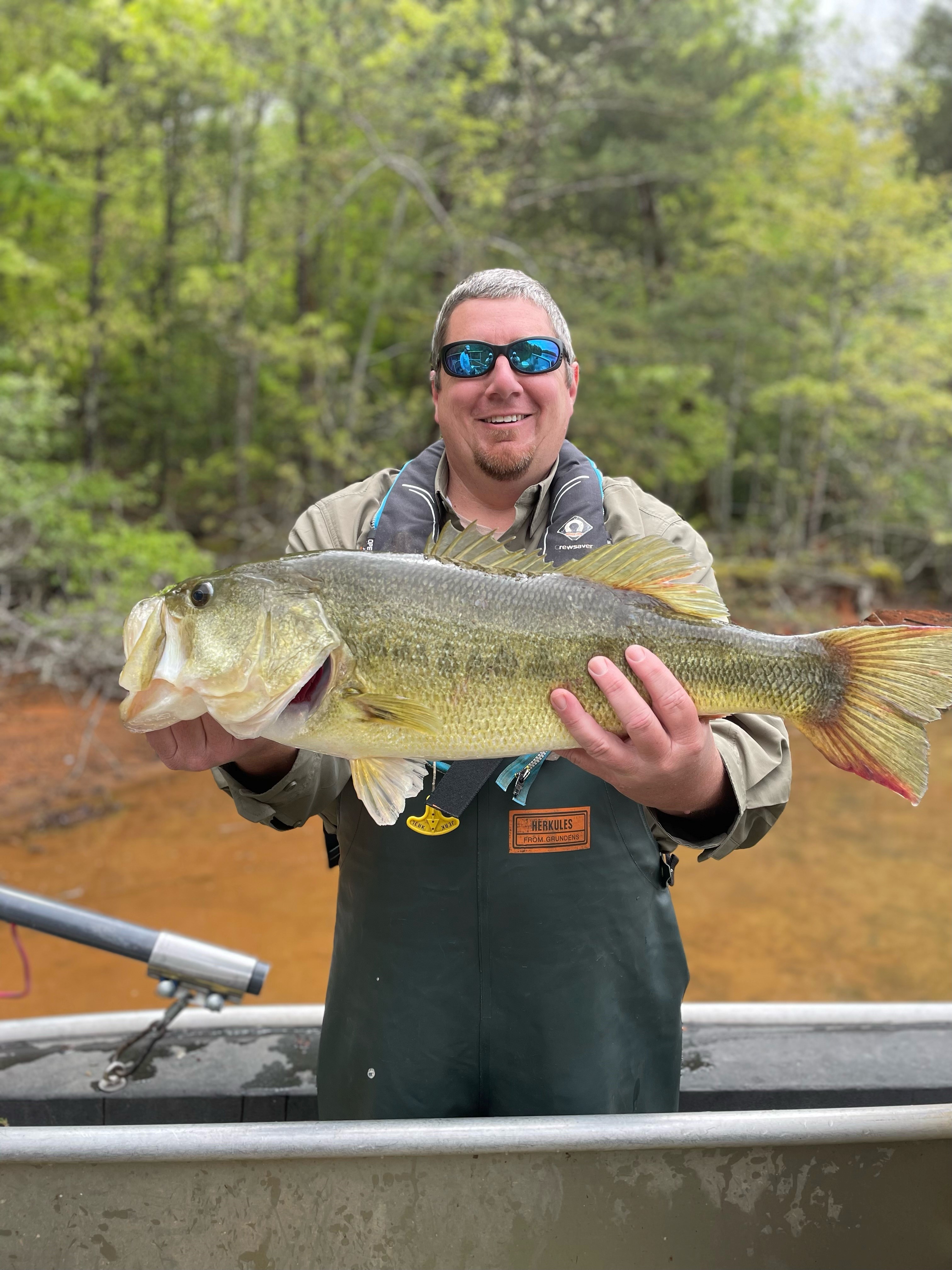 Matt Hinman holding a fish while on a small boat.